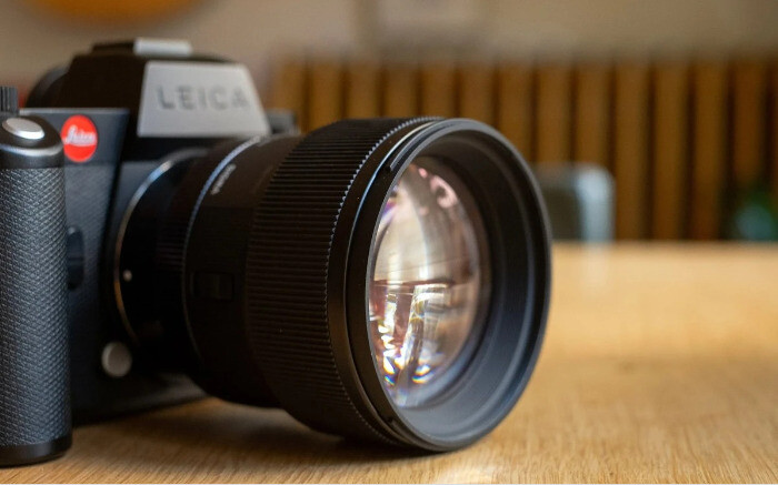 Крупний план опуклої передньої лінзи об'єктива Sigma 85mm f/1.4 DG DN Art з багатошаровим просвітленням на камері Leica SL